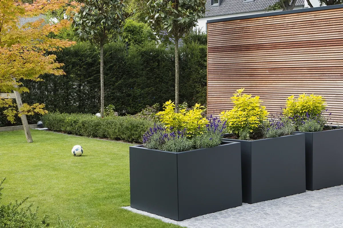 Drie antraciete metalen plantenbakken